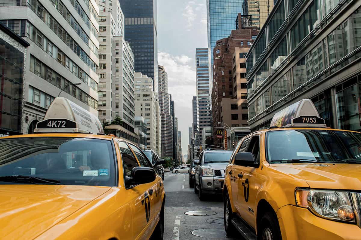 A group of yellow taxi cabs on a street in New York City, showcasing the vibrant urban landscape.