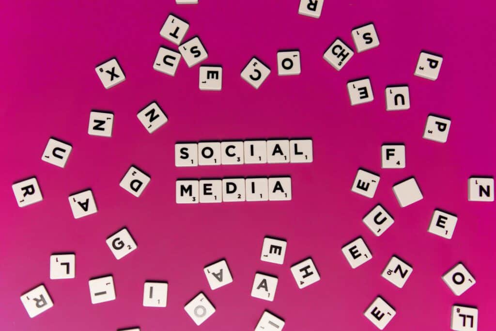 The word social media spelled out on a pink background.